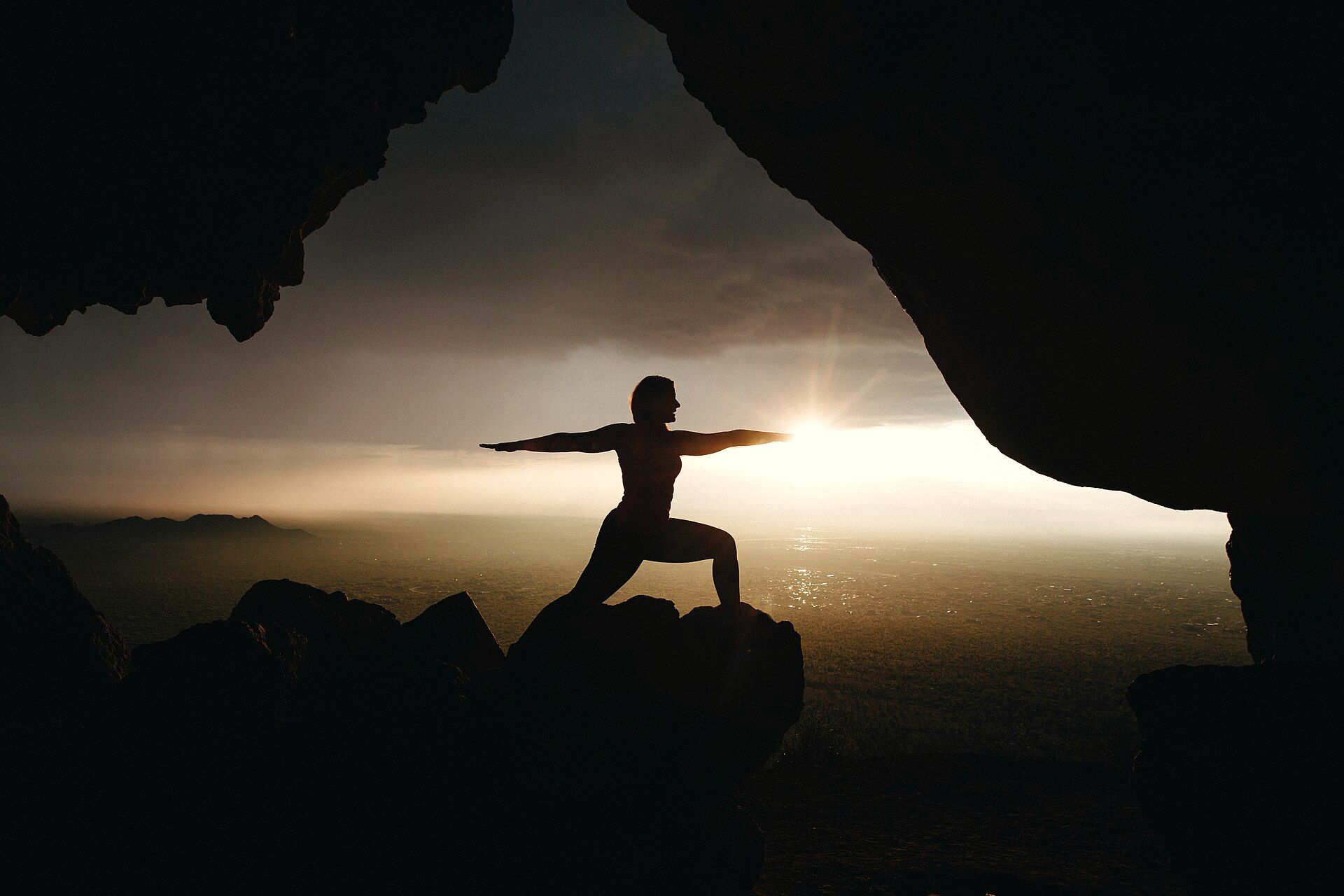 Silhouette of a yoga pose against a sunrise